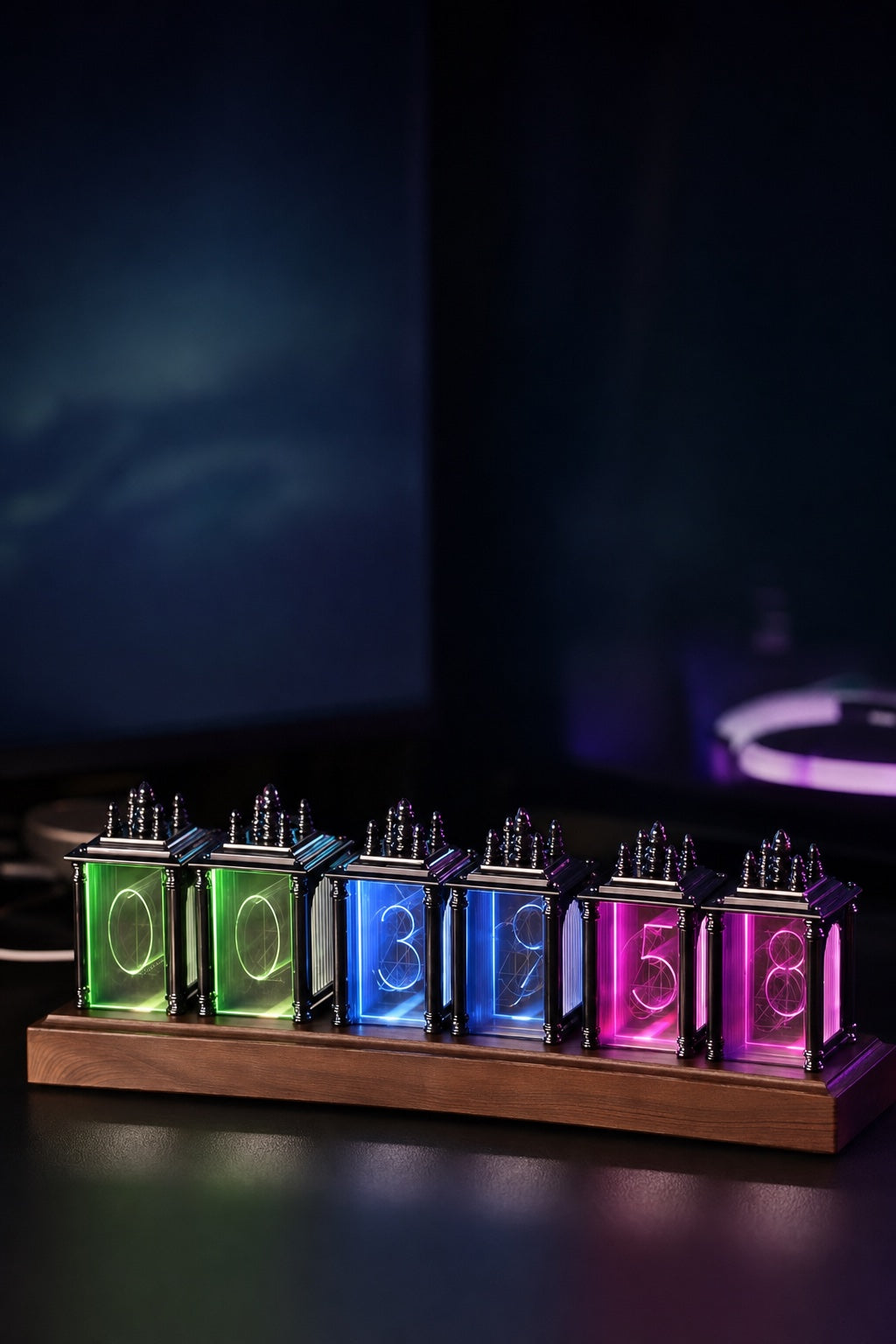 Reloj de tubos RGB NIXEL brillando en colores sobre un escritorio de madera por la noche